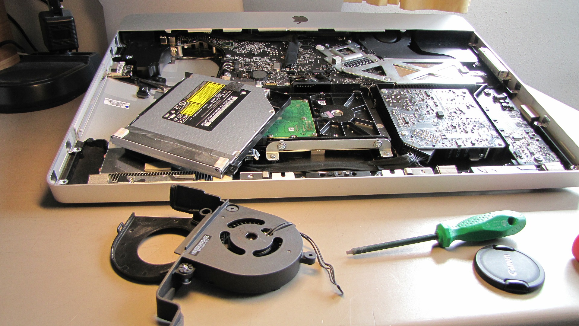 Laptop computer with visible internal components and a screwdriver
